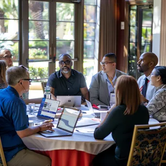 Diverse professionals seated at a round table in a conference session - Image 2