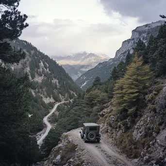 Antique vehicle on steep mountain pass with pine forests - Image 2