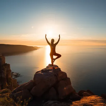 Woman practicing yoga on a cliff overlooking the ocean. - Image 3