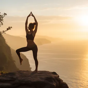 Woman practicing yoga on a cliff overlooking the ocean. - Image 4