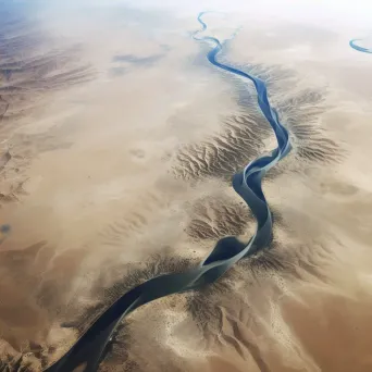 High-resolution satellite image of an arid desert landscape with a winding river, sand dunes, and sparse vegetation. - Image 4