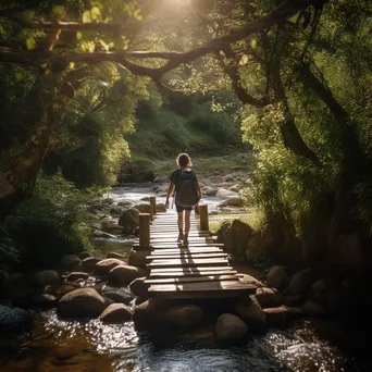 A backpacker crossing a wooden bridge over a stream - Image 4