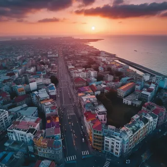 Aerial view of a coastal city at sunset with vibrant architecture - Image 1