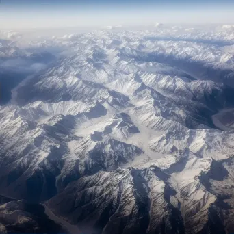 Snow-covered mountains seen from airplane window in winter - Image 2