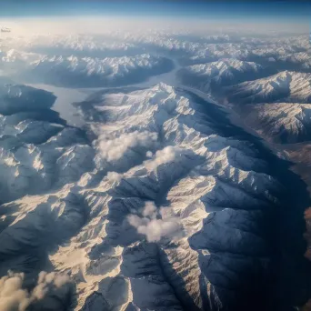 Snow-covered mountains seen from airplane window in winter - Image 3