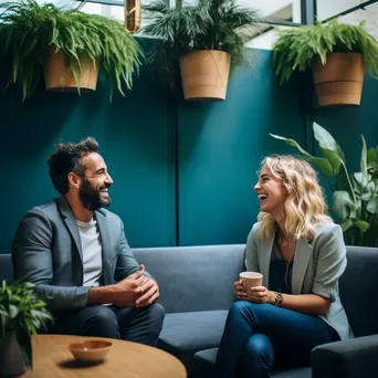 Two colleagues sharing laughter over coffee in a cozy breakout area - Image 3