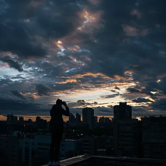 Rooftop silhouette against dramatic clouds and skyline - Image 3