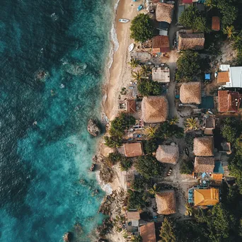 Aerial view of a coastal village with thatched roofs and ocean - Image 1