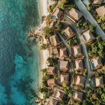 Aerial view of a coastal village with thatched roofs and ocean - Image 2