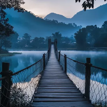 Rope bridge over a serene lake with mountains - Image 4