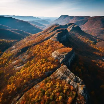 Aerial view of a mountain ridge surrounded by autumn foliage - Image 1