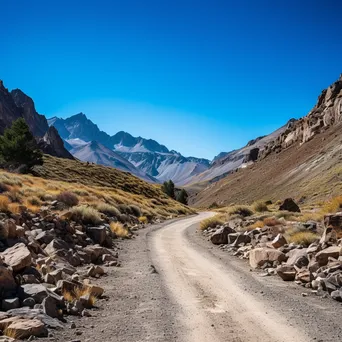 High-altitude mountain pass with gravel road and rock formations - Image 1