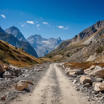 High-altitude mountain pass with gravel road and rock formations - Image 3