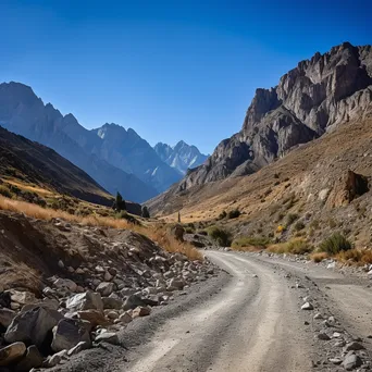 High-altitude mountain pass with gravel road and rock formations - Image 4