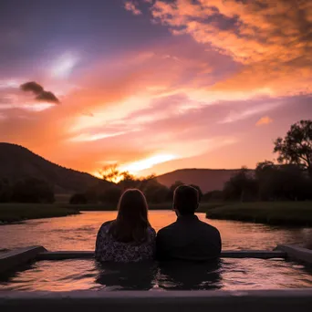 A couple relaxing in a thermal spring during a picturesque sunset. - Image 4