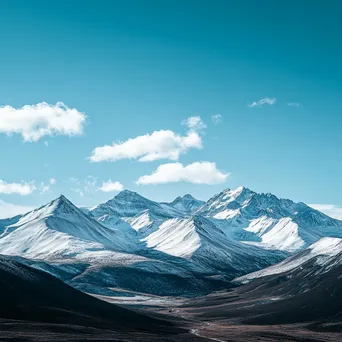 Panoramic view of snow-capped mountain ridges under blue sky - Image 3