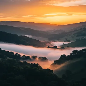 Sunset over a misty valley with warm colors and fog - Image 2