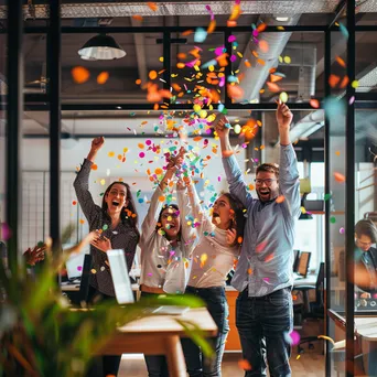 Startup team celebrating product launch with confetti in an office. - Image 4