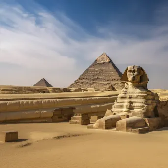 Great Sphinx of Giza with pyramids in the background and desert sands - Image 4