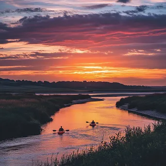 Kayakers paddling in coastal estuary at sunset - Image 2