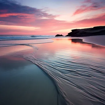 Long exposure photo of a coastal sunset with smooth water and reflective sand - Image 4