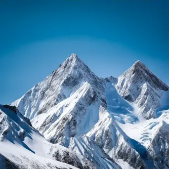 Snow-covered mountain peaks under a clear blue sky - Image 3