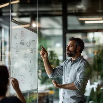 Entrepreneur brainstorming on a glass whiteboard in a bright office. - Image 4