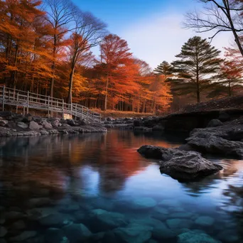 Thermal spring surrounded by colorful autumn foliage reflecting in the water. - Image 3