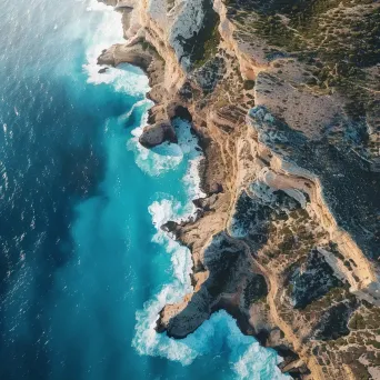 Coastal cliffs and turquoise sea seen from airplane window in aerial shot - Image 1