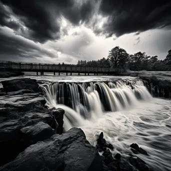 Black and white image of a traditional weir under stormy sky - Image 2