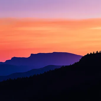 Silhouette of rugged mountain ridges against a colorful sunset - Image 4