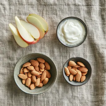 Flat lay of healthy snacks including almonds and apple slices - Image 3