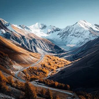 Winding mountain road through autumn landscape with snow-capped peaks - Image 1