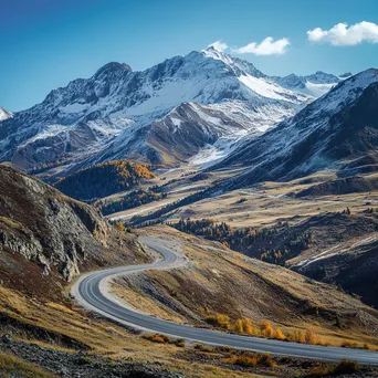 Winding mountain road through autumn landscape with snow-capped peaks - Image 3