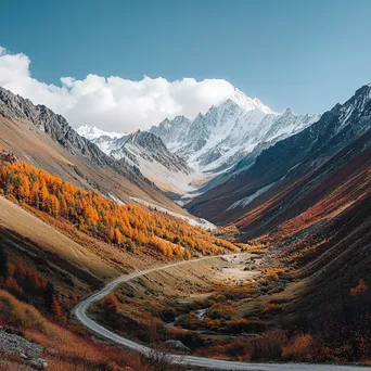 Winding mountain road through autumn landscape with snow-capped peaks - Image 4