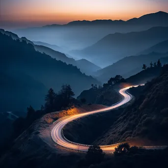 Mountain pass at twilight with trees and rocky silhouettes - Image 1