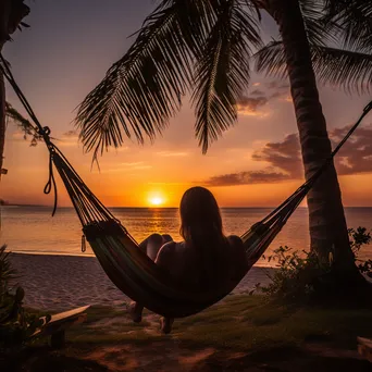 Freelancer working on laptop in hammock at sunset - Image 1