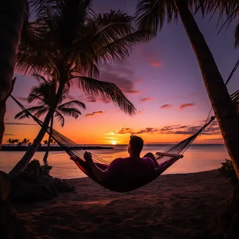 Freelancer working on laptop in hammock at sunset - Image 2