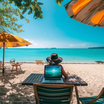 Freelancer using laptop on a beach with umbrellas - Image 2