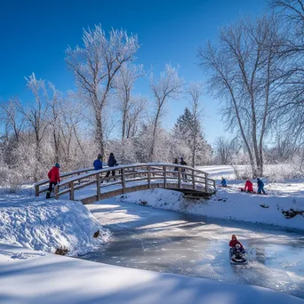 Children tobogganing near a snowy bridge - Image 3