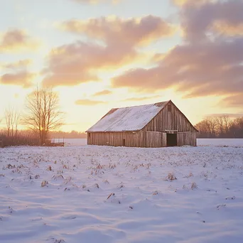 Rustic barn in winter field at sunset - Image 1