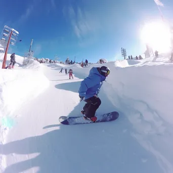 Snowboarders and skiers performing tricks in a winter snow park - Image 3