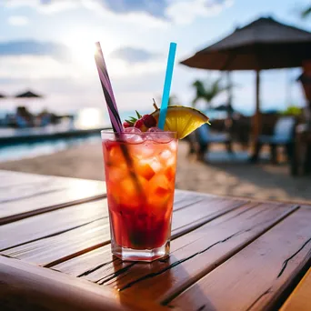 Close-up of a tropical drink on a seaside table with blurred beach scenery in the background. - Image 1