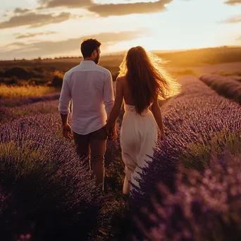 Couple walking hand in hand in lavender fields. - Image 1