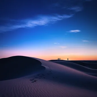 Silhouettes of people wandering through sand dunes at twilight - Image 3