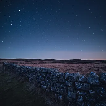 Dry stone wall set against a starry sky at twilight. - Image 2