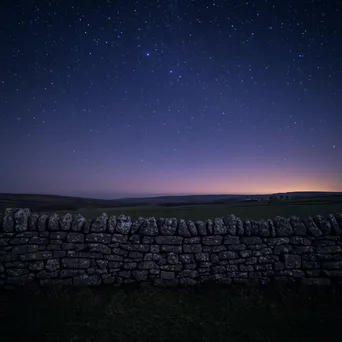 Dry stone wall set against a starry sky at twilight. - Image 4