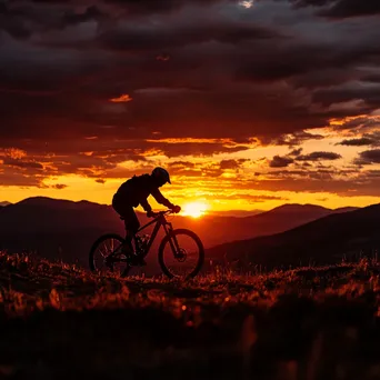 Silhouette of a mountain biker against a colorful sunset backdrop. - Image 2