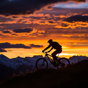 Silhouette of a mountain biker against a colorful sunset backdrop. - Image 4