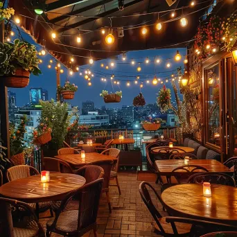 Elegant cafe terrace with string lights and city views at night - Image 2